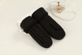 Close-up of black cable knit mittens featuring plush fur cuffs and decorative props - One Size / Black