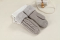 Detail of light gray cable knit mittens featuring elegant faux fur cuffs on beige fabric - One Size / Light Gray
