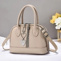 Close-up of pebble grain crossbody bag with crystal heart pendant and tassel detail - Light Khaki