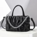 Pleated black crossbody bag with silver chain strap on a modern geometric display - Black