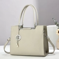 Gros plan du sac en cuir beige avec pendentif étoile argenté et détails en perles - 26cm x 12cm x 20cm / Gris