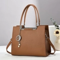 Détail du sac à main en cuir grainé caramel avec pendentifs étoile et perle argentés - 26cm x 12cm x 20cm / Marron