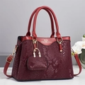 Red snake pattern patchwork handbag with mini pouch charm and gold hardware on grey background - Red
