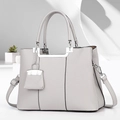 Light gray pebbled leather handbag with silver hardware and mini charm accessory - Gray