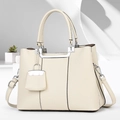 Close-up of cream lychee-textured leather handbag with silver hardware and charms - Off White