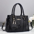 Elegante borsa nera con motivo a serpente, dettagli dorati e mini ciondolo abbinato - Nero