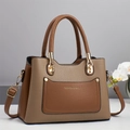 Detailed macro view of khaki and brown lychee grain leather stitching and gold hardware - Brown
