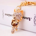 Golden lucky cat keychain with white crystals and a large amber gemstone accent - Coffee