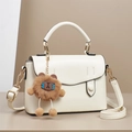 Dettaglio borsa a mano bianca in pelle con ciondolo a forma di orso e finiture dorate - Bianco Sporco