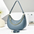 Detailed close-up of blue-grey pebble leather hobo bag with a chunky gold chain and silver logo - Blue