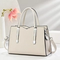 Elegant cream structured handbag with silver hardware and detachable strap in a minimalist setting - Off White