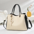 Bolso elegante blanco y negro con logo dorado y colgante de corazón en exposición - Negro con Blanco
