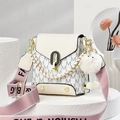 Chic cream monogram crossbody bag with pink strap and plush charm on geometry stand - Off-white
