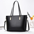 Dettaglio della borsa tote nera lucida con eleganti fibbie in metallo dorato - Nero
