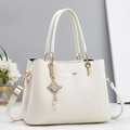 Dettaglio della borsa a mano bianca in pelle martellata con pendente a catena dorata - Bianco