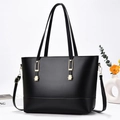 Borsa tote nera classica con doppi manici e finiture dorate su uno sfondo minimalista - Nero