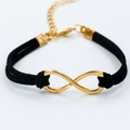 Golden infinity symbol charm bracelet with double-strand black suede leather cord - Black