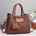 Détail de la texture en toile tissée marron et rabat en cuir d'un sac à main trapèze chic - Jaune Terre