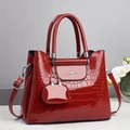 Detail of red croc-embossed patent leather handbag with gold logo and mini pouch charm - With Pouch Pendant / Red