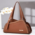 Detail of brown woven tote bag with golden chain accent and brand logo nameplate - Brown