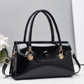 Detailed shot of glossy black patent leather bag with shell-shaped gold hardware details - Black
