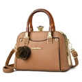 Brown faux leather handbag with amber handles and rose charm shown from side angle - Earthy Yellow