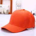 Detail of an orange cotton baseball cap showing twill texture and reinforced stitching - Orange