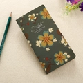 Detail of dark green notebook featuring floral pattern and artistic Style lettering text - 90*170mm / Green