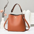 Detail of caramel brown bucket bag showing lychee texture and gold brand logo - Khaki/Earth Yellow