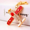 Airplane keychain with gold finish, red enamel wings and sparkling crystal rhinestones - Red Fighter Jet