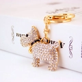 Sparkling gold dog keychain with crystal rhinestones on an elegant book background - White