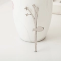 Elegant silver leaf hair clip with floral details resting on a white ceramic mug - Bird Silver