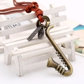 Collier en cuir vintage avec un pendentif saxophone en laiton et des plaques gravées - Corde en cuir marron clair