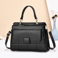 Détail d'un sac à main noir avec garnitures dorées et texture matelassée élégante - Noir