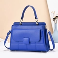 Sac à main élégant en cuir bleu matelassé avec poignée et finitions dorées sur fond neutre - Bleu