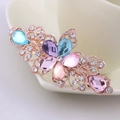 Floral hair clip with gold base, blue and purple crystals, and pink gemstones - Colorful