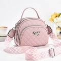 Quilted pink crossbody bag with triple zippers, metal bow, and woven shoulder strap - 21x11x18 / Pink