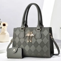 Detail of dark grey quilted handbag featuring gold swan charm and pearl ornament - Gray