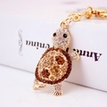 Golden turtle keychain with brown and white crystals on an open book background - Coffee Turtle