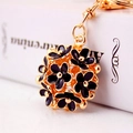 Macro shot of gold metal ball pendant with black flower inlay and delicate chain detail - 4*3.5 / Black
