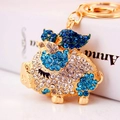 Portachiavi creativo maialino volante con strass blu su base in metallo dorato - Blu