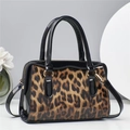 Dettaglio macro della borsa leopardata con pelle verniciata nera e fibbie dorate - Marrone
