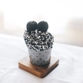 Cozy black and white speckled coral fleece cake socks rolled into a cupcake shape - One Size / Black & White