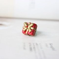 Makroaufnahme eines roten Geschenkbox-Rings mit goldener Schleife und hellblauem Band - Weihnachtsgeschenkbox 13MM