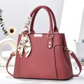 Dettaglio borsa a tracolla in pelle rosa con foulard di seta sul manico e decori oro - Rosa
