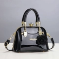 Chic black patent leather handbag with gold hardware and a decorative rose pendant - Black