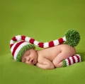 Macro detail of handmade crochet baby Christmas hat and matching striped leg warmers - Hat + Foot Covers