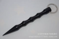 Gros plan d'un kubotan noir en aluminium avec rainures antidérapantes et pointe fine - Tête Pointue Noir