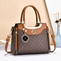 Brown monogram handbag with golden AA logo and adjustable strap in elegant setting - Coffee