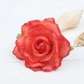Detailed top view of red artificial silk rose hair clip on a white wooden background - Orange Red